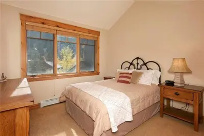 a bedroom with a bed and a window at Private 3 Bedroom Townhome Located In East Keystone With Access To A Firepit, Hot Tub, And Billiards in Keystone