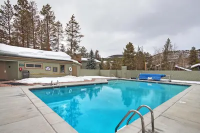 a swimming pool with blue water in a yard at 1182 Flying Dutchman condo in Keystone