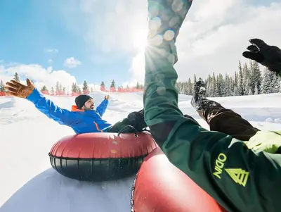 a group of people laying in the snow on a sled at Premier 2BR 2BA in Lakeside Village- Kids Ski Free! condo in Keystone