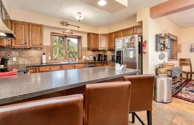 a large kitchen with wooden cabinets and a large counter at Divine Destiny Luxury Home at Windcliff condo in Estes Park