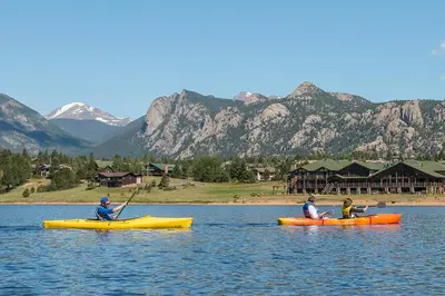 three people in kayaks on a lake with mountains at Cozy & Relaxing – Indoor/Outdoor Fireplace, Jacuzzi and BBQ grill in Estes Park