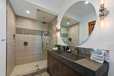 a bathroom with a shower and a large mirror at Cozy & Relaxing – Indoor/Outdoor Fireplace, Jacuzzi and BBQ grill in Estes Park