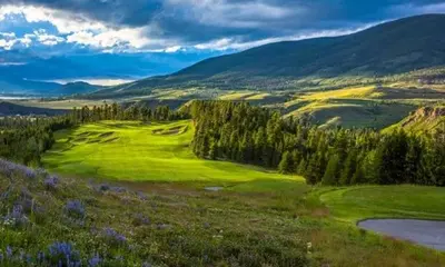 a golf course in the hills with trees and a field at Full Renovated 1BR -Walk to Gondola & Kids Ski Free condo in Dillon