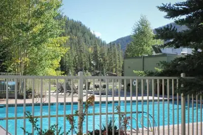 a white fence next to a swimming pool at Lakeside Village 4 Bedroom Condo in Keystone