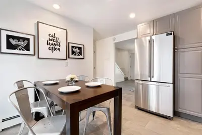 a kitchen with a dining table and a refrigerator at Comfortable Abode Near Historic Downtown in Loveland