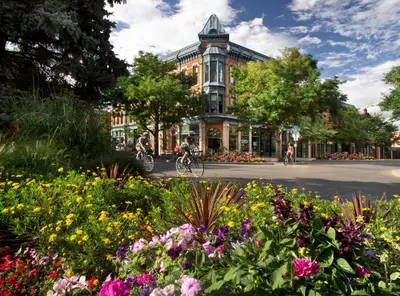 a group of people riding bikes down a street with flowers at Ultimate Chill Zone, BBQ, Bikes, Pet Friendly!! in Fort Collins