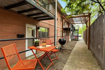 a patio with a table and chairs and a grill at Contemporary condo in the heart of Old Town in Fort Collins