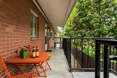 a patio with a wooden table and chairs on a balcony at Gorgeous Condo in the Heart of Old Town in Fort Collins