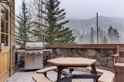 a patio with a picnic table and a grill at Arapahoe Lodge by Summit County Mountain Retreats in Keystone