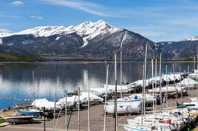 a bunch of boats docked at a marina with a mountain at The Lodge at Lake Dillon 111 in Dillon