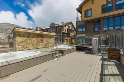 a hot tub on a deck next to a building at Slopeside by Summit County Mountain Retreats in Keystone