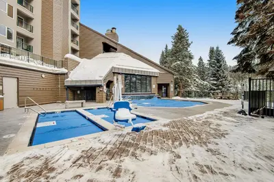 a house with a swimming pool and a blue chair at Iron Horse Studio Retreat in Winter Park