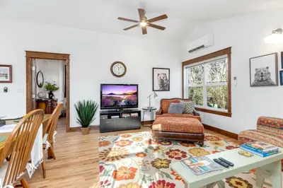 a living room with a table and a tv at The Beautiful Bears Den! Walk to Old Town and CSU! in Fort Collins