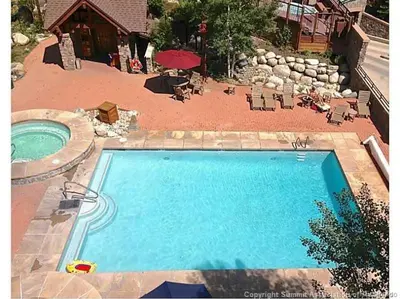 a swimming pool in a yard with a patio and a house at 8282 Silver Mill condo in Keystone
