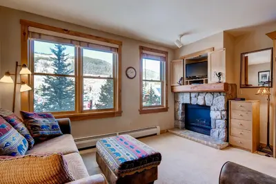 a living room with a couch and a fireplace at River Run Village by Vail Resorts in Keystone