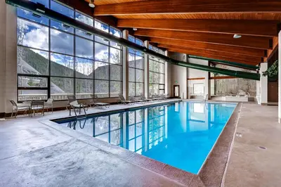 a swimming pool in a large building with windows at Evergreen Condominiums by Vail Resorts in Keystone