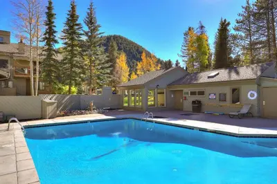 a large blue swimming pool in front of a house at 1168 Flying Dutchman condo in Keystone