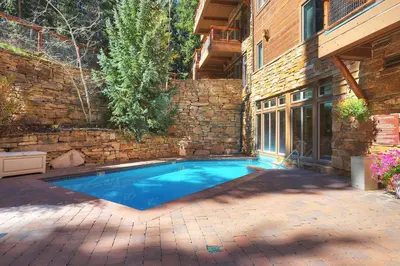 a swimming pool in a yard next to a brick wall at 3059 The Timbers condo in Keystone