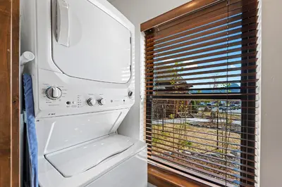 a white refrigerator in a kitchen with a window at Chic Lakefront Cabin - Unbeatable Views! Jacuzzi, Two Patios, Indoor/Outdoor Fireplace in Estes Park