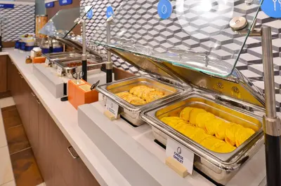 a buffet line with trays of food on it at Holiday Inn Express & Suites - Firestone - Longmont by IHG in Longmont