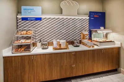 a bakery with a counter with donuts on it at Holiday Inn Express and Suites Denver East Peoria Street by IHG in Denver
