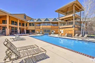 a resort with a swimming pool and lounge chairs at Cozy Granby Mountain Condo with Resort Amenities! in Granby