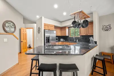 a kitchen with a island with black counter stools at Cutty Sark Grand Combo 6BR 4,5BA townhouse in Silverthorne