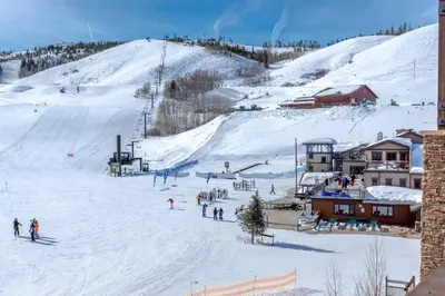 a group of people skiing down a snow covered slope at Steps to Conquest Ski Lift Granby Home with Grill in Granby