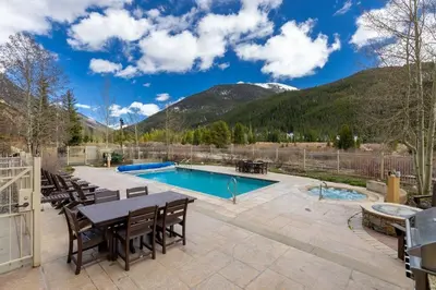 a patio with a table and chairs and a swimming pool at 2348 Red Hawk Townhomes condo in Keystone