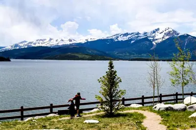 two people standing next to a fence near a lake at Buffalo Woods 216 - Wildernest in Silverthorne