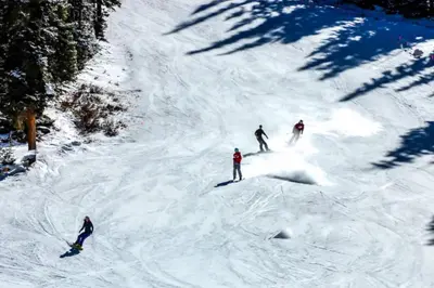 a group of three people skiing down a snow covered slope at Lake Ridge at Lake Dillon in Dillon