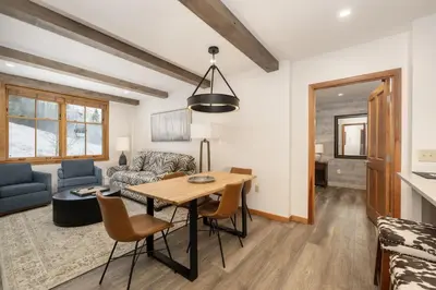 a living room with a table and a couch at Beautiful Zephyr Mountain Lodge condo with Slope Base View condo in Winter Park