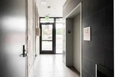 a hallway with an open door and a door sidx sidx sidx at Walk to Gameday - Jefferson Park Condo - Tesoro in Denver