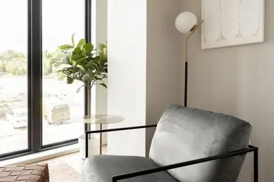 a living room with a chair and a table at Brand New Condo - Walk to Empower Stadium - Tesoro in Denver