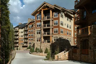 a large apartment building in the middle of a street at Luxurious 2 BR in River Run Village with Ski in ski out, Kids Ski Free condo in Dillon