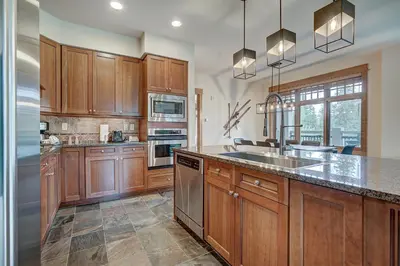 a kitchen with wooden cabinets and stainless steel appliances at Luxurious 3 BR in River Run Village with Ski-In Out condo in Dillon