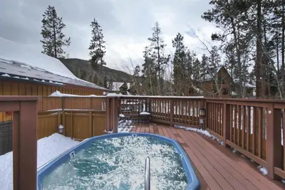 a hot tub on a deck in the snow at Charming Condo Nestled In The East Keystone Resort Neighborhood, Shuttle To Ski Slopes, Outdoor Pool And Hot Tub in Dillon