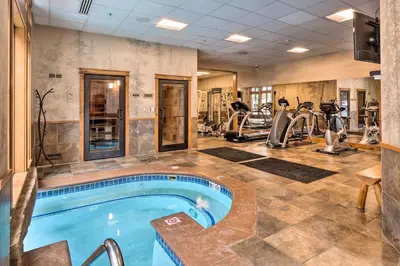 a gym with a swimming pool and exercise equipment at Ski-Out Keystone Resort Condo with Private Balcony in Keystone