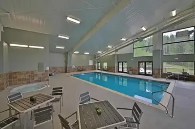 a large pool with tables and chairs in a building at Hi Country 816 in Winter Park