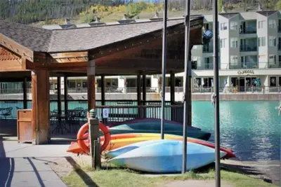a boat parked under a pavilion next to the water at 2 Bedroom Condo In West Keystone Near Lakeside Village in Keystone