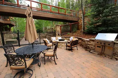 a patio with a table and chairs and a grill at The Timbers In River Run 2 Bedroom Condo in Dillon