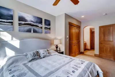 a bedroom with a large bed and two paintings on the wall at The Timbers In River Run 2 Bedroom Condo in Dillon