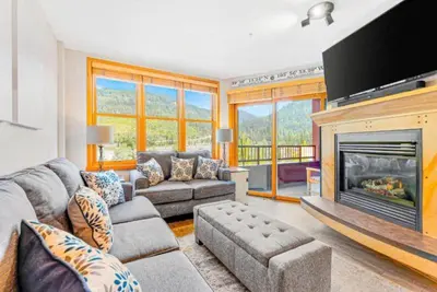 a living room with a couch and a fireplace at Silvermill Lodge 1 Bedroom In River Run Village in Keystone