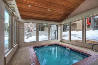 a swimming pool in a house with windows at Luxury 2 Bedroom Condo with Pool Hot Tub and Sauna in Keystone