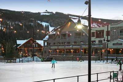 a person skating on an ice rink in front of a lodge at Expedition Station 8593 by SummitCove Lodging in Keystone