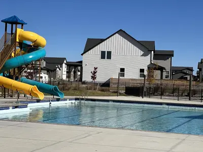 a swimming pool with a slide in front of a house at Modern & Stunning Home near Breweries and Old Town in Fort Collins
