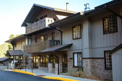 a large brick building with a balcony on a street at King Bed Condo with Personal Hot Tub on Deck with River View condo in Estes Park