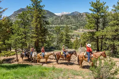a group of people riding horses on a dirt road at Elk Haven! Two Large Patios, Private Jacuzzi, Indoor/Outdoor Fireplace in Estes Park