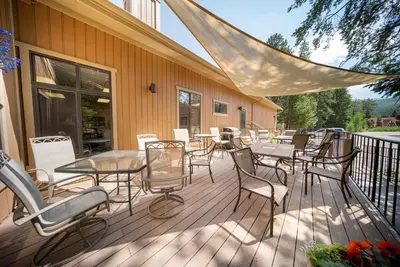 a deck with tables and chairs on a building at Beaver Village Unit #0211 in Winter Park