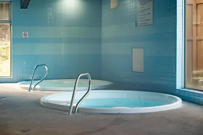 two hot tubs in a bathroom with blue tiles at Beaver Village Unit #0332 in Winter Park